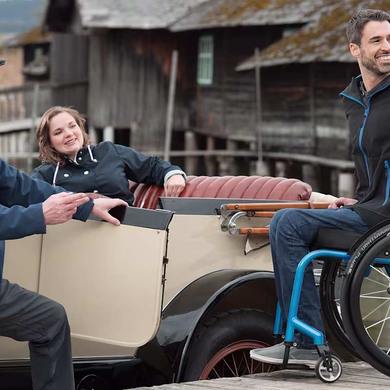 A dark-haired man sitting in an Ottobock Invader Wave wheelchair for active use.