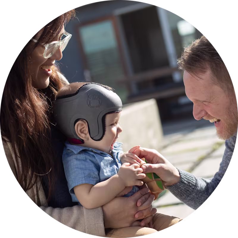 Harrison wears a MyCRO Band helmet and laughs with his parents
