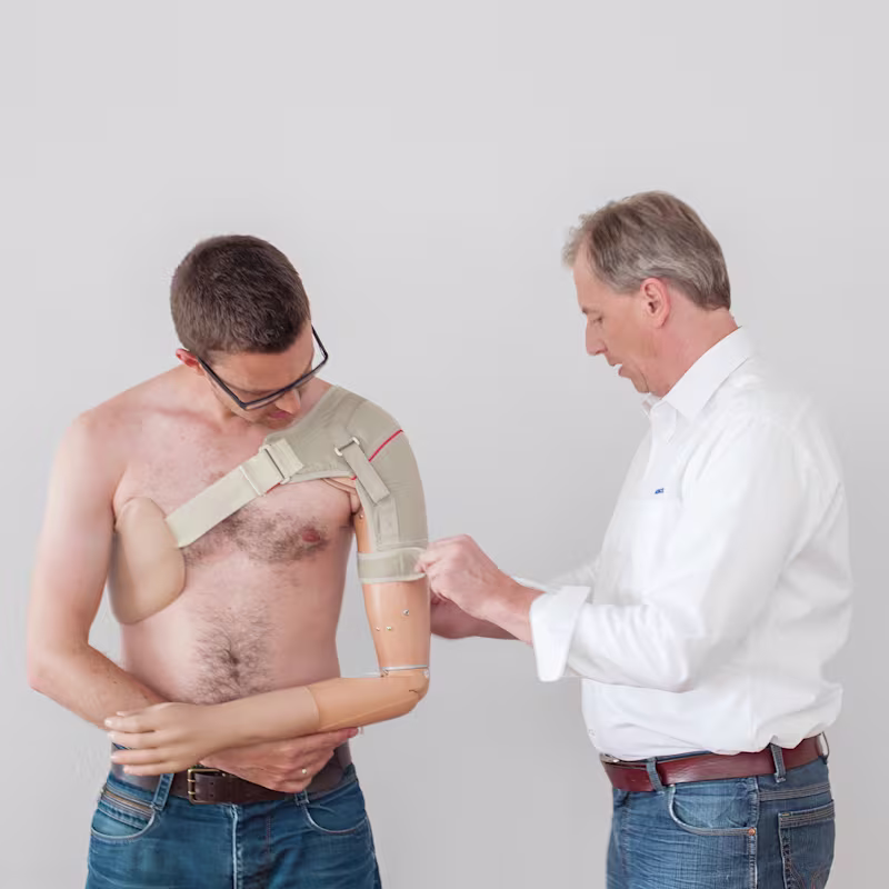 A shoulder disarticulation amputee being fitted with a prosthetic shoulder by a Certified Prosthetist Orthotist