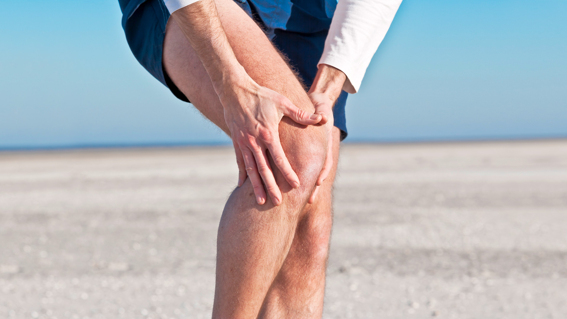 Zoom to a person's knee grabbing it due to pain