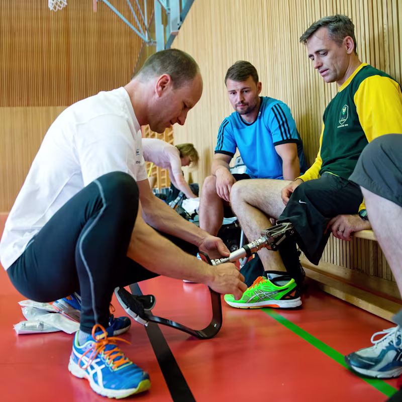 A Certified Prosthetist Orthotist configuring a running blade on an adaptive athlete