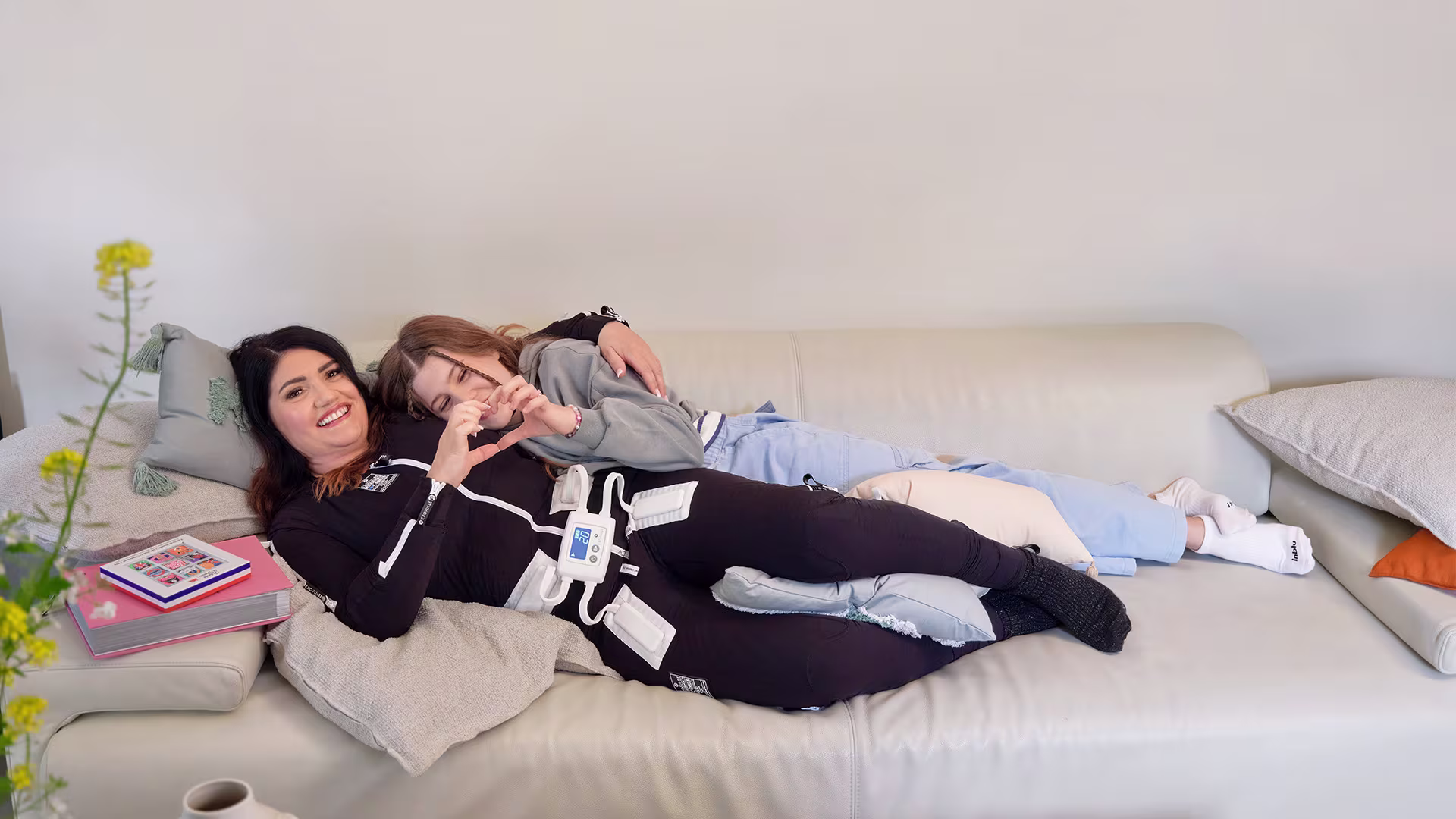 Ottobock Exopulse Mollii Suit user Elisa and little girl cuddling on sofa
