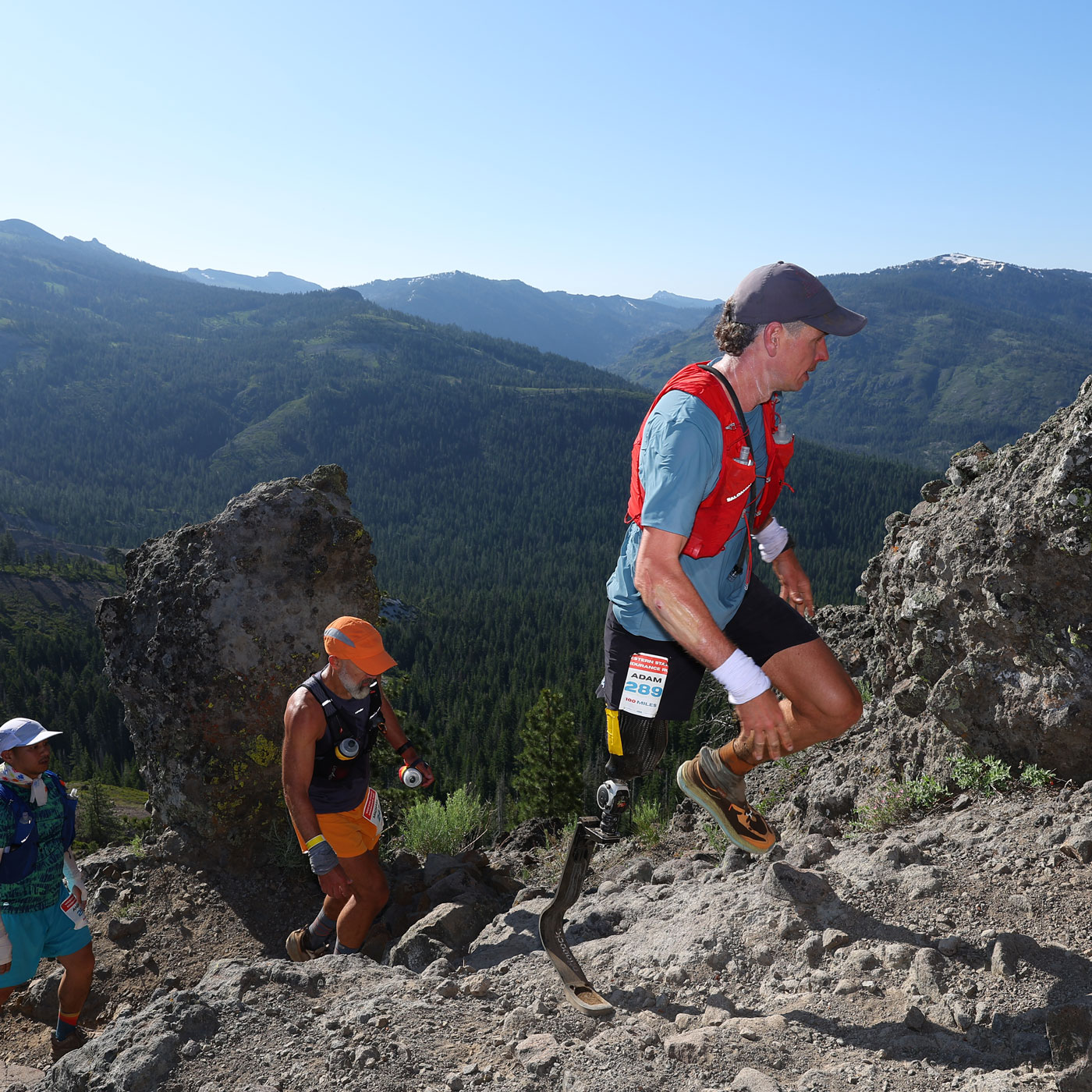 Prosthetic blade user Adam Popp hiking on a mountainous terrain