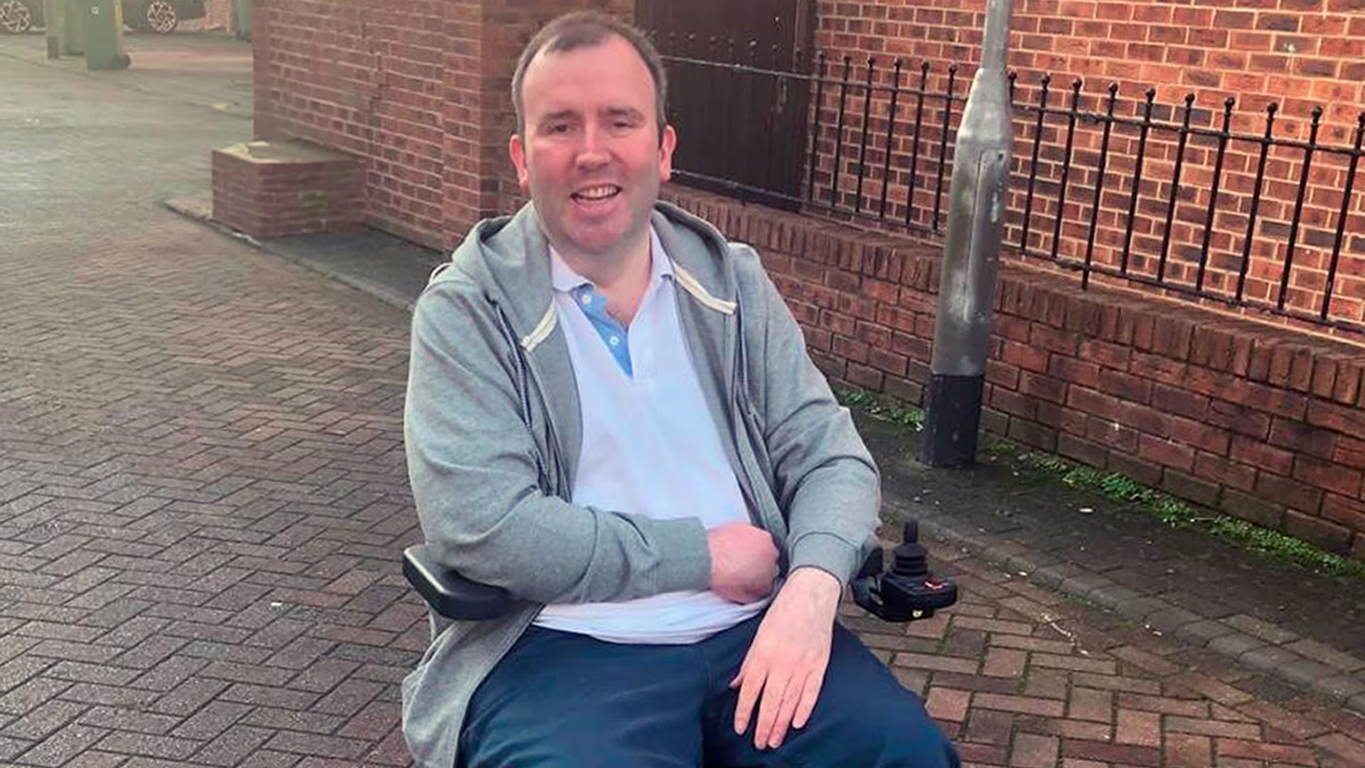 Ottobock Wingus utilizzatore di carrozzina su una strada lastricata di mattoni.