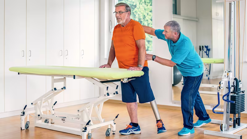 Detlef, Kenevo Mikroişlemcili Diz'i kullanma pratiği yapmak için terapistiyle birlikte çalışıyor.