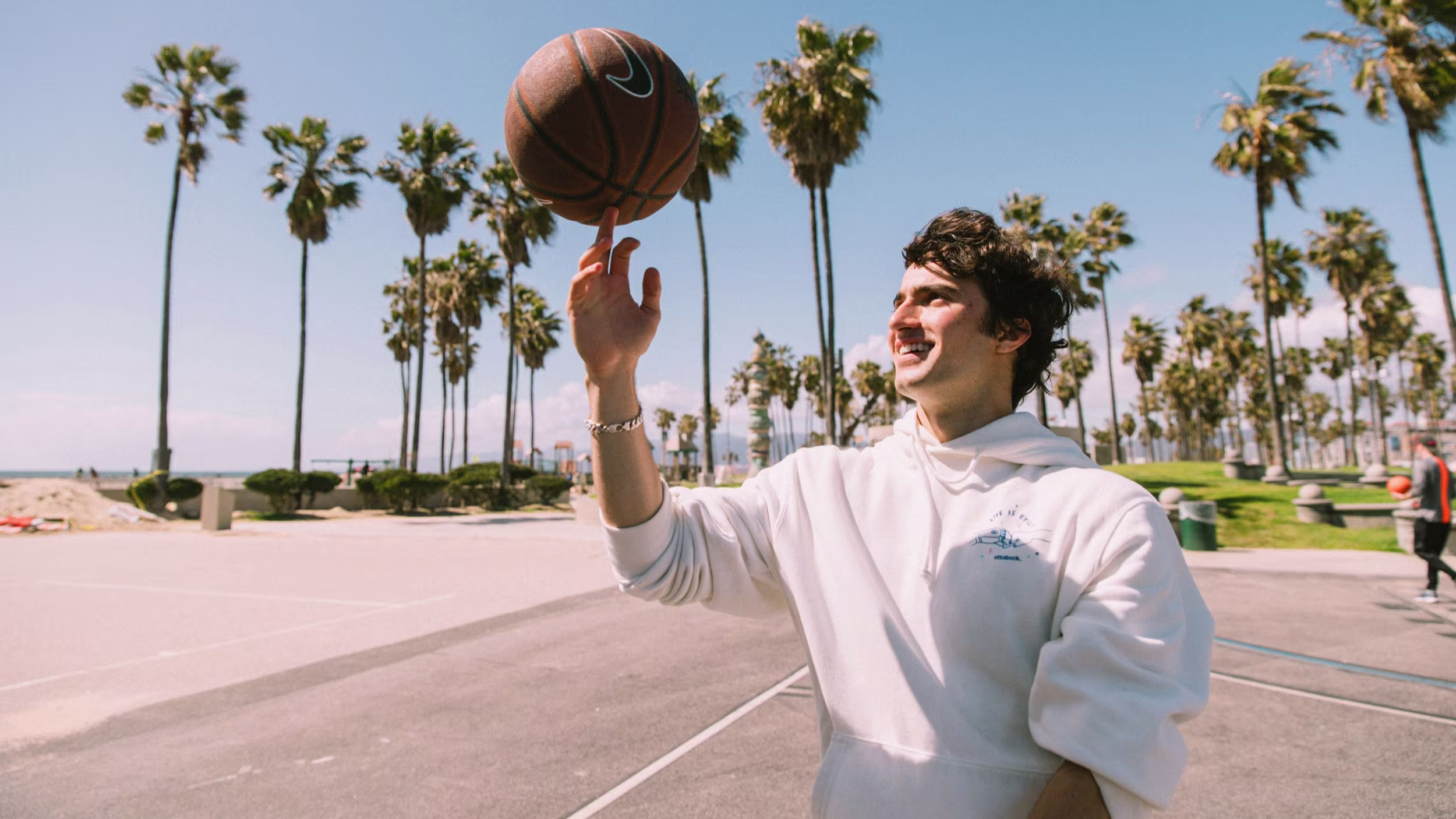Ottobock Ambassador Ezra Frech playing with a basketball at a beach