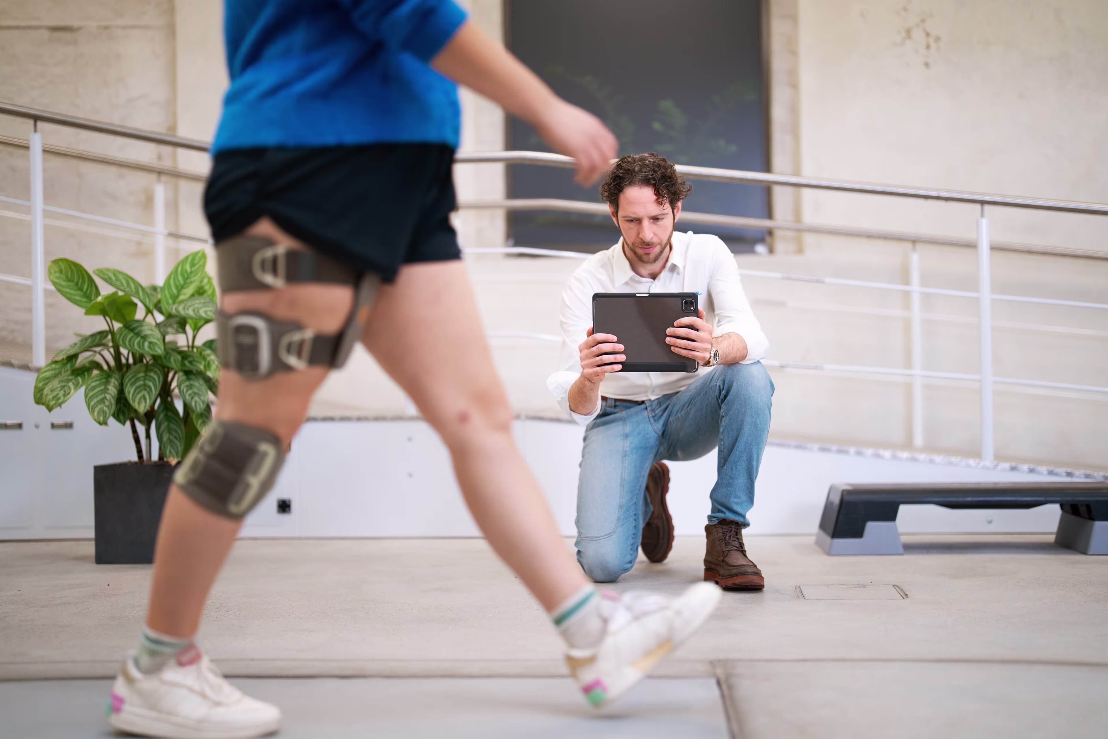 Healthcare professional using a tablet to record his patient walking with L300 Go.