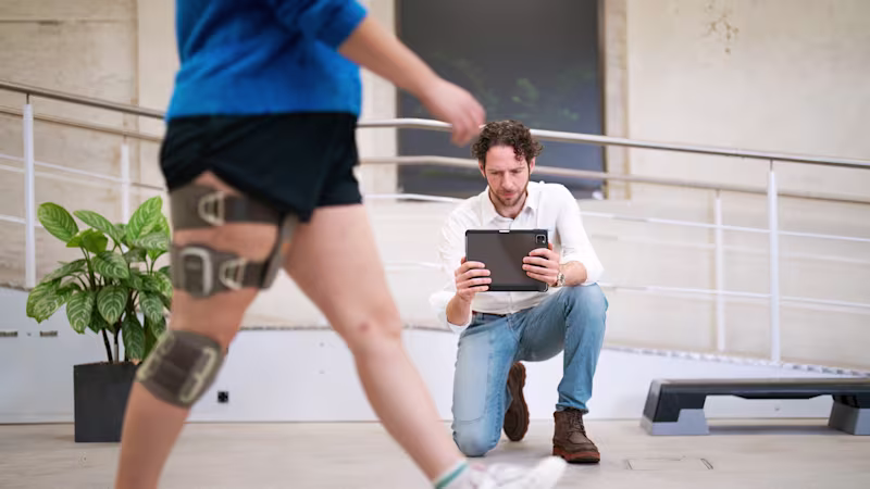 Medizinische Fachkraft nimmt eine Frau beim Gehen mit Exopulse Suit und L300 Go auf.