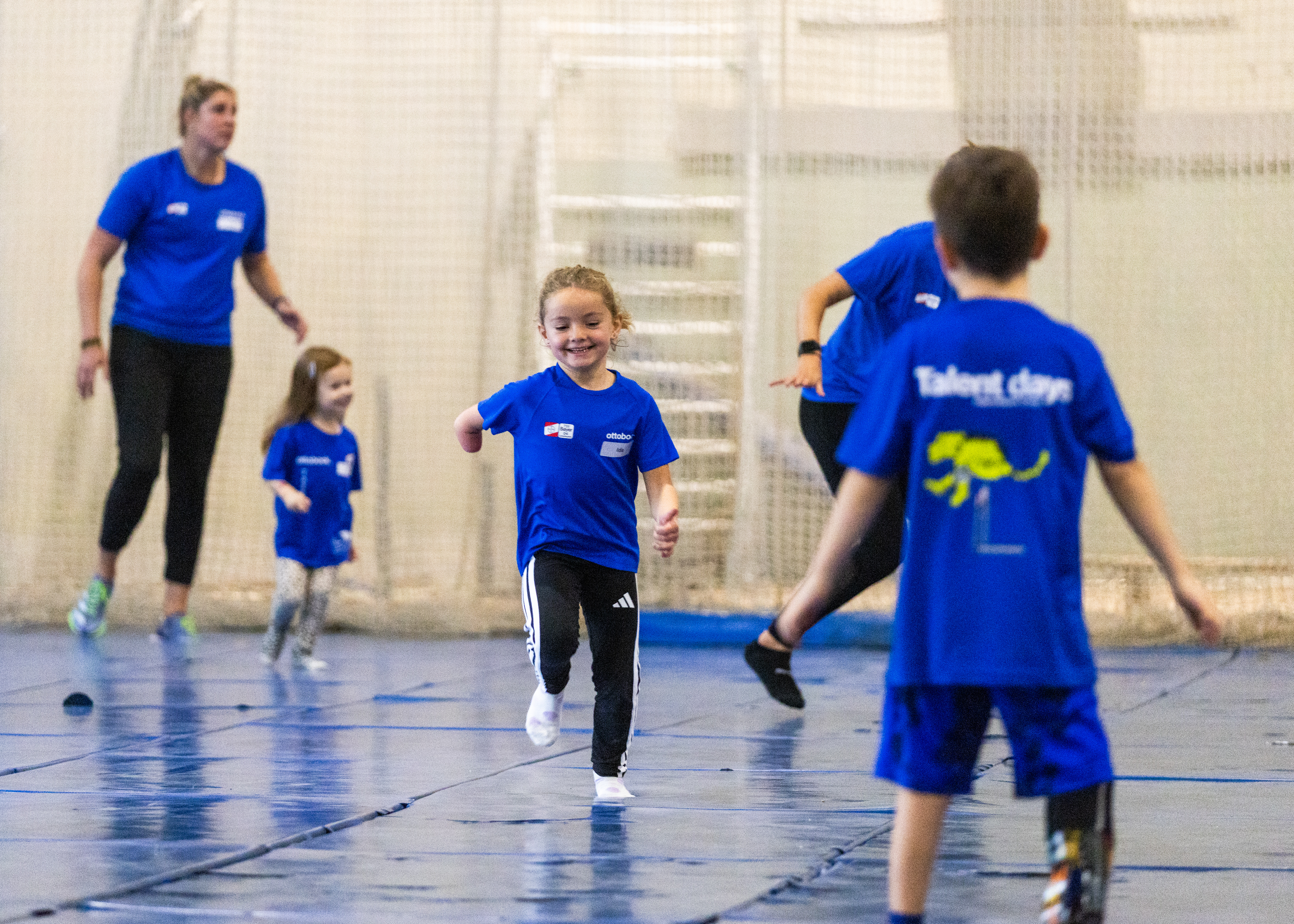 Auf dem Bild sieht man im Mittelpunkt ein kleines Mädchen mit einer Armamputation. Um sie herum spielen anderen Kinder, sie sind auf den Talent Days 2025. 