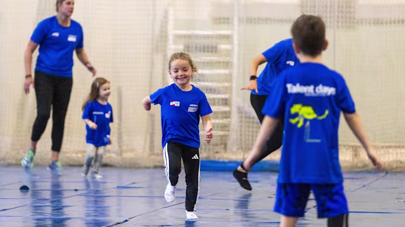 Auf dem Bild sieht man im Mittelpunkt ein kleines Mädchen mit einer Armamputation. Um sie herum spielen anderen Kinder, sie sind auf den Talent Days 2025.