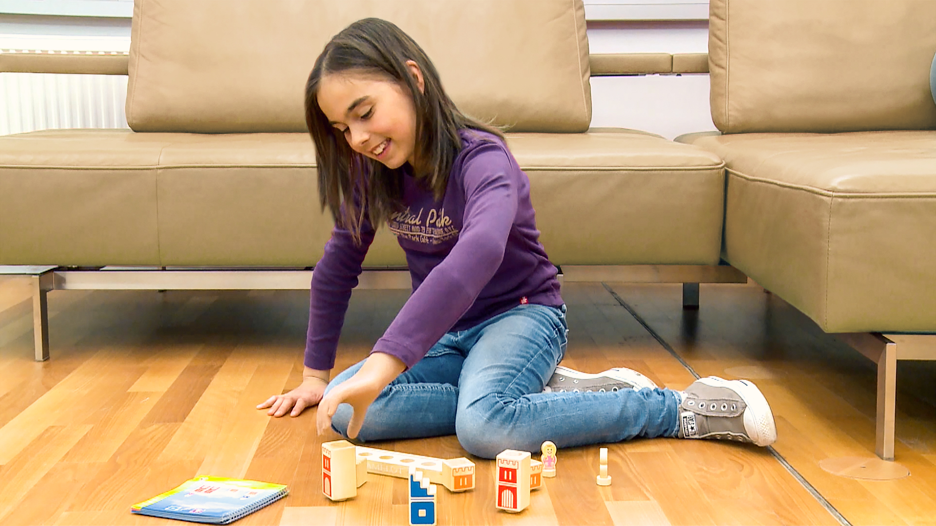Denise, an Ottobock prosthetic hand user, happily playing with toys and enjoying independence.