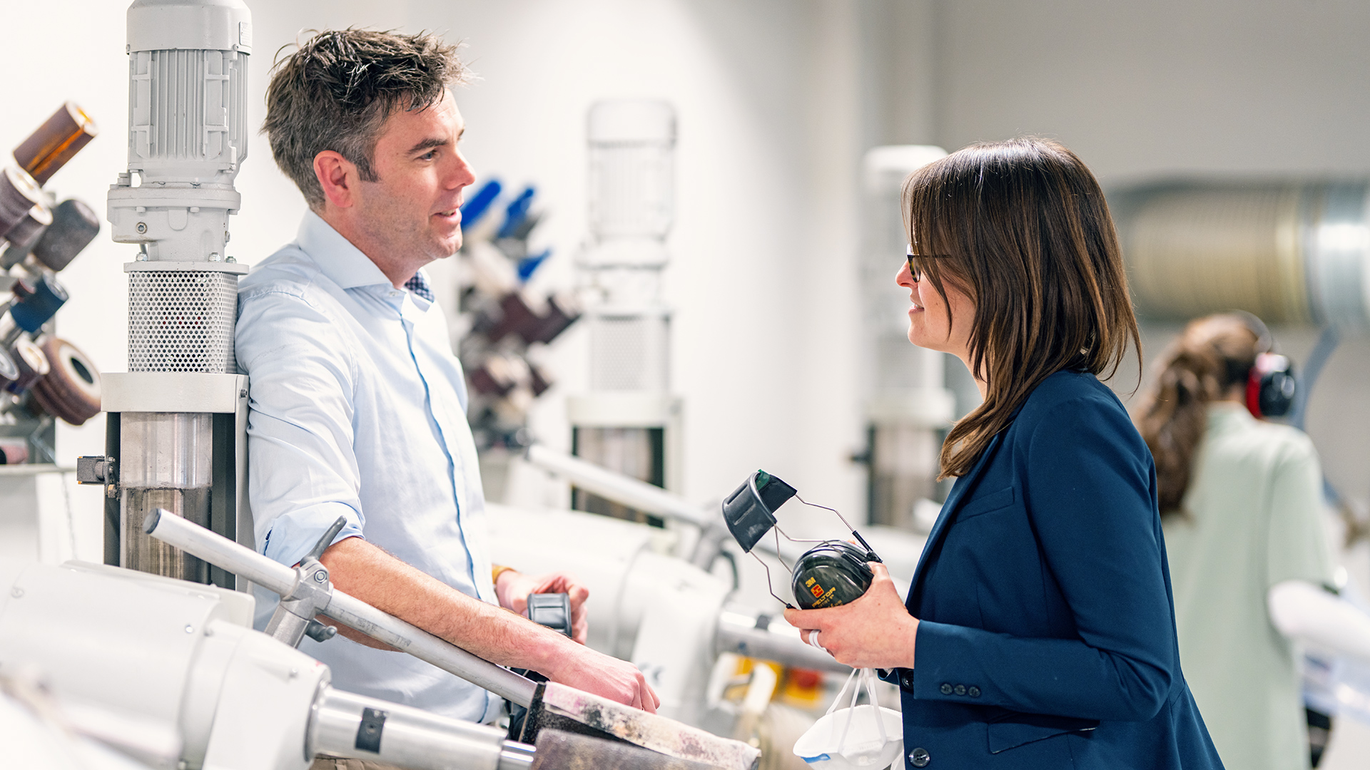 Il consulente aziendale Ottobock e l'amministratore delegato di un negozio di forniture protesiche discutono nell'officina ortopedica tra le fresatrici.