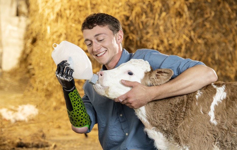 Wolfgang mit bebionic Hand füttert ein Kälbchen mit der Flasche