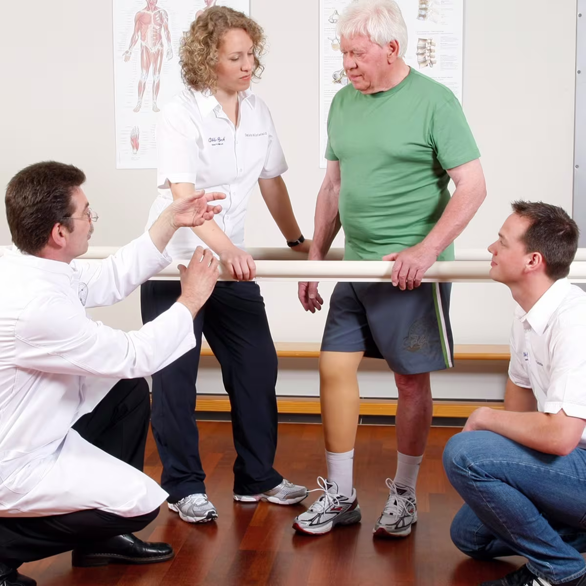 An amputee is accompanied by O&P professionals as he trials a leg prothesis