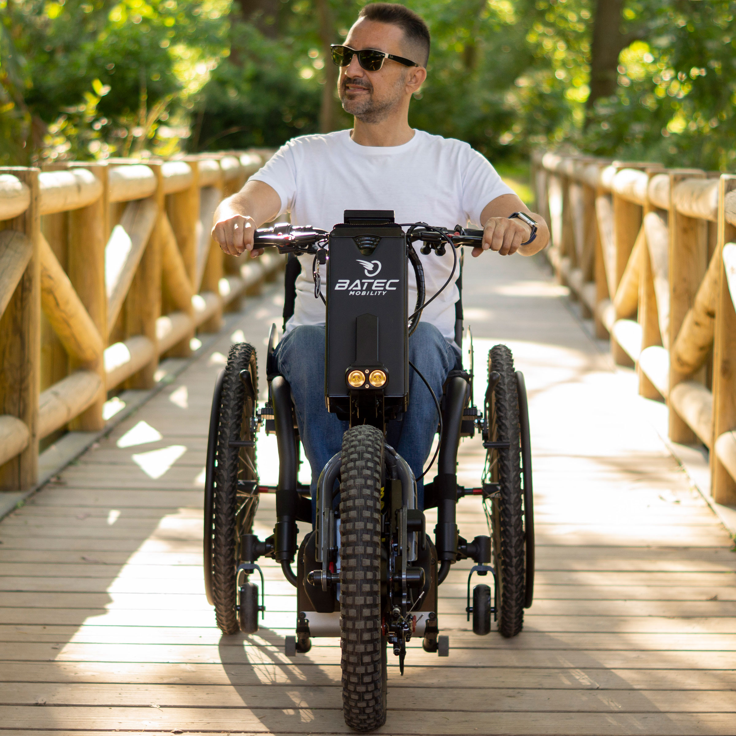 Utente Batec Scrambler 2 attraversa un ponte di legno a bordo della sua handbike elettrica