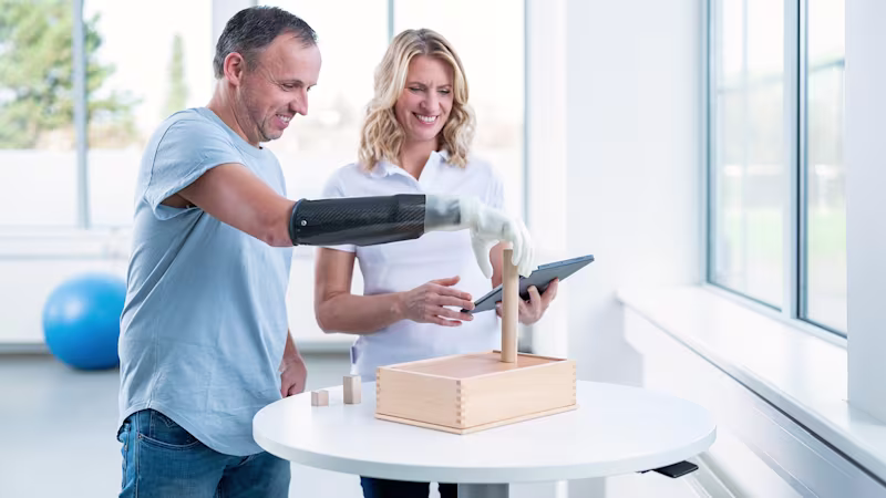A prosthesis user practices different grip patterns with the help of a therapist.
