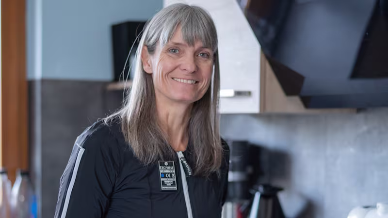 Marion in cucina sta preparando il pranzo mentre indossa la neurotuta Exopulse