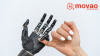 A prosthetic hand and a human hand grasp each other with the little finger