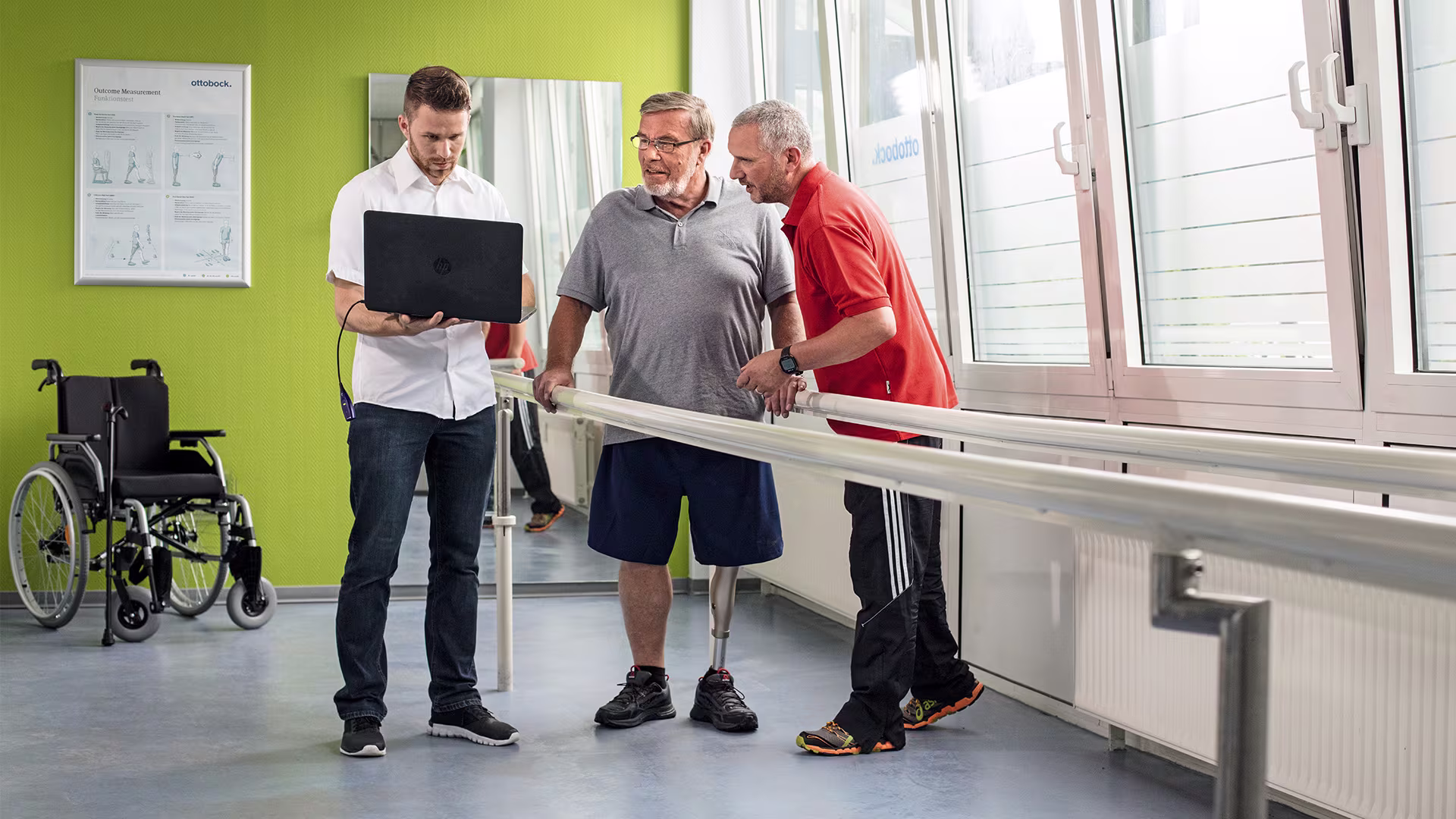Zwei Therapeuten versorgen einen unterschenkelamputierten Mann mit einem Kenevo Kniegelenk von Ottobock