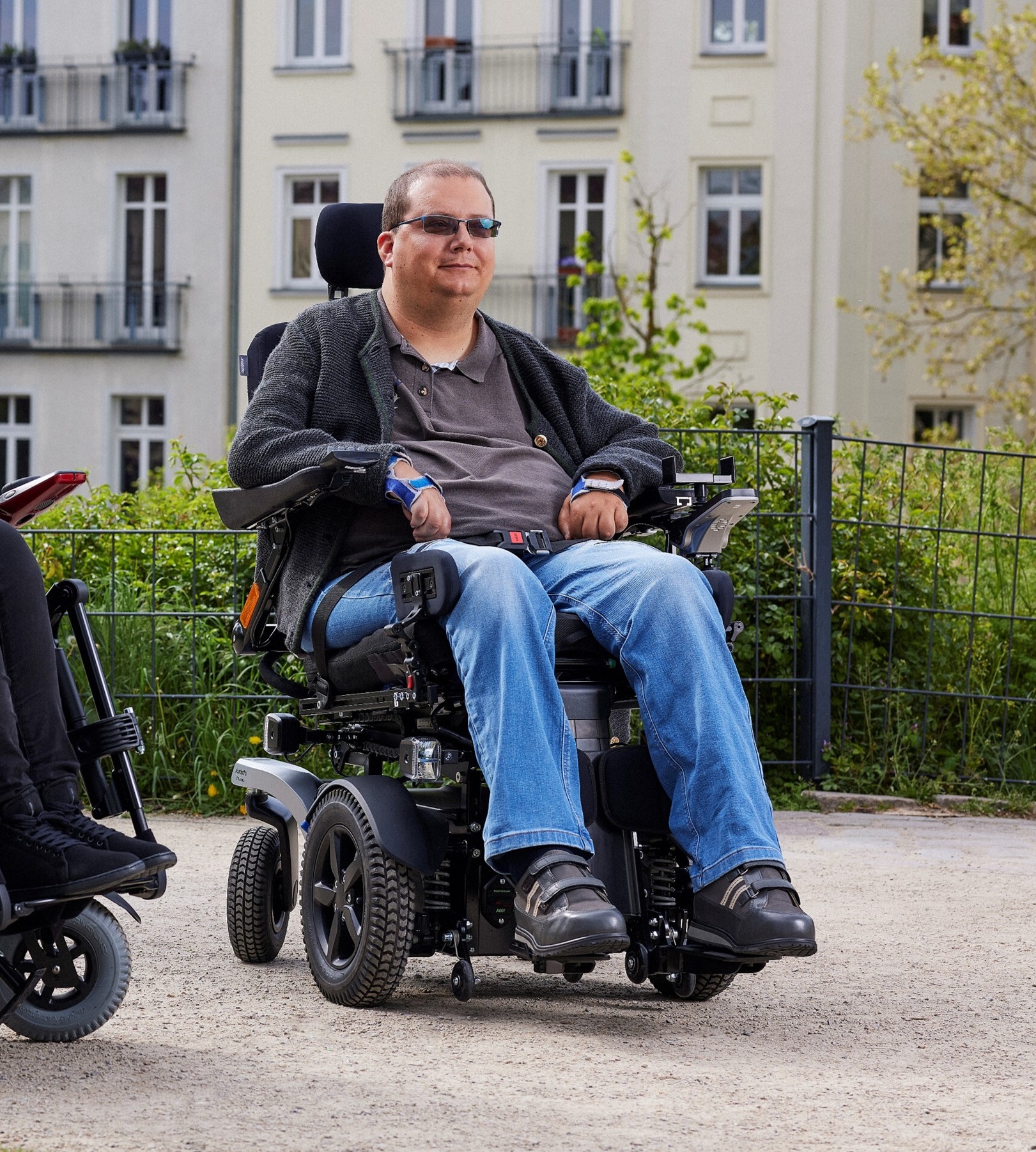 Power wheelchair user Tobias is in Ottobock Juvo B7, relaxing outside at a park in Berlin and enjoying the sun.