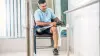 A leg prosthesis user puts tennis shoes on his artificial foot