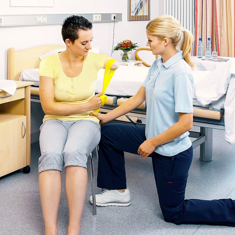 An orthotic and prosthetic professional teaching an amputee strengthening techniques for their supporting muscles