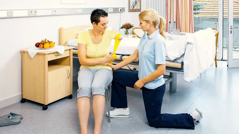 An orthotic and prosthetic professional teaching an amputee strengthening techniques for their supporting muscles