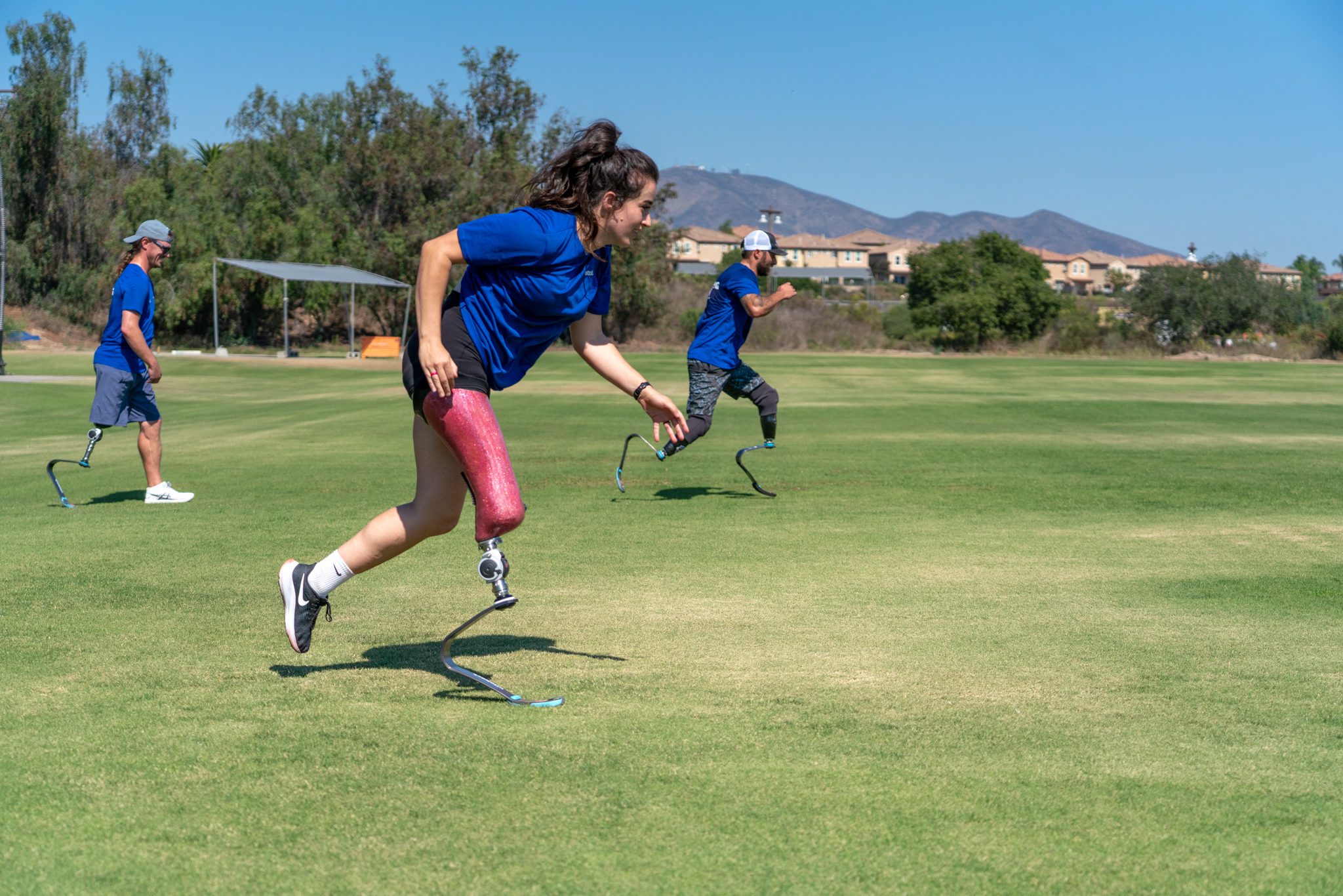 A lower limb prosthetic user running on an outdoor field to test out Ottobock's Sports Prostheses