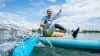 Een gebruiker van een prothesevoet zwemt in een boot