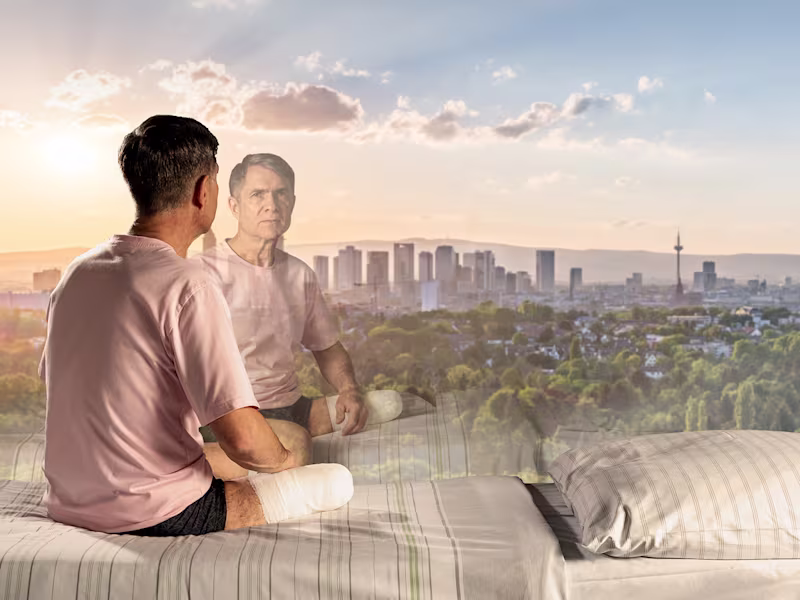 Man after amputation looks out of window