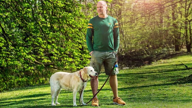 Genium kullanıcısı Axel köpeğiyle birlikte parkta duruyor.