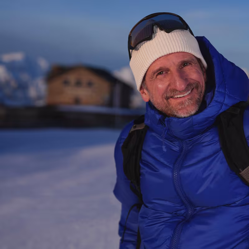 Ein Prothesenträger wandert auf einem Berg mit viel Schnee. Er trägt das mechatronische Prothesenkniegelenk Genium X4 von Ottobock.