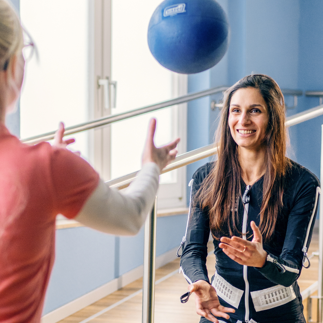 Ottobock Exopulse Mollii Suit user, Louisa, throws a ball to the physiotherapist