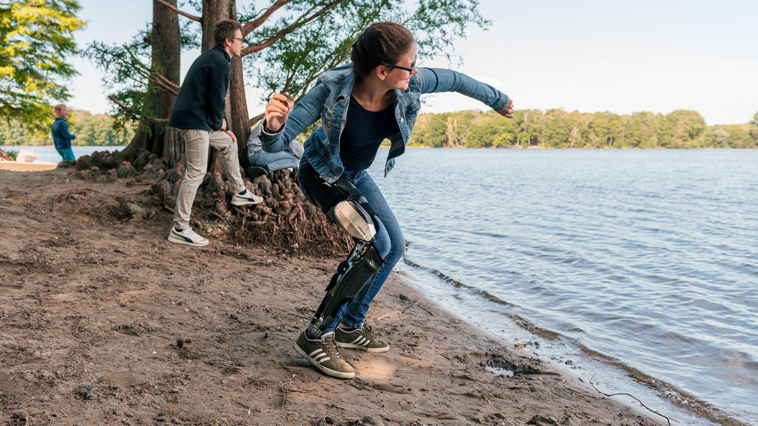 Denise al lago che lancia un sasso con il suo C-Brace