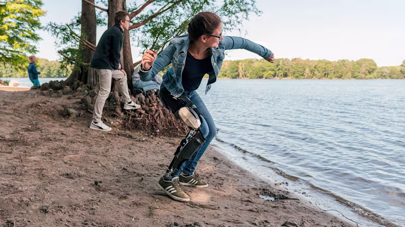 Denise al lago che lancia un sasso con il suo C-Brace