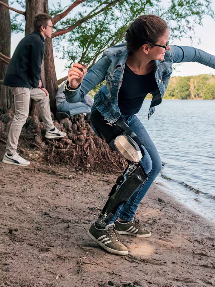 Denise al lago che lancia un sasso con il suo C-Brace