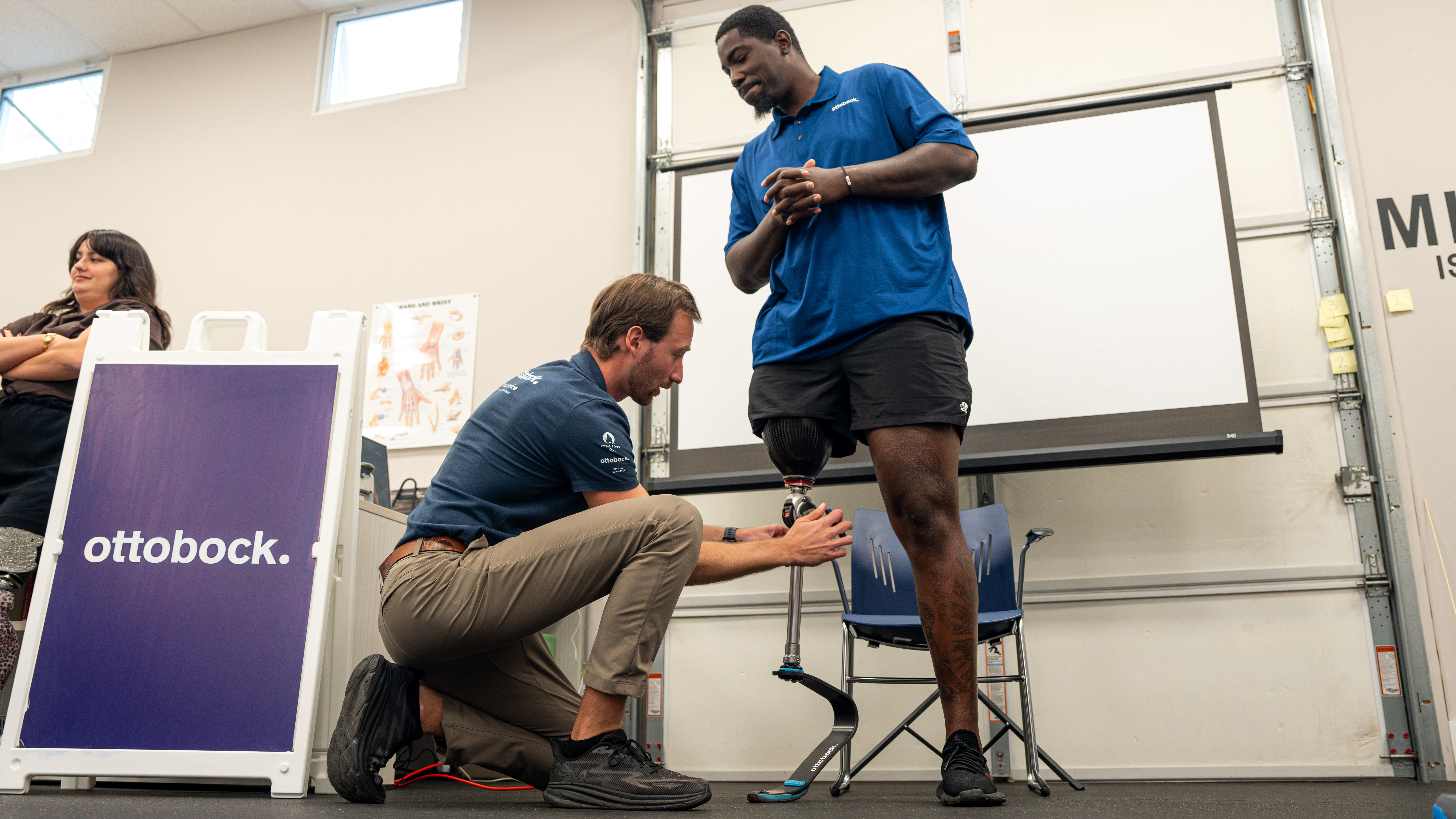 A prosthetic technician adjusts a mechanical prosthetic knee on an amputee as a demonstration during The Athlete's Corner, a continuing education unit event for Certified Prosthetists Orthotists