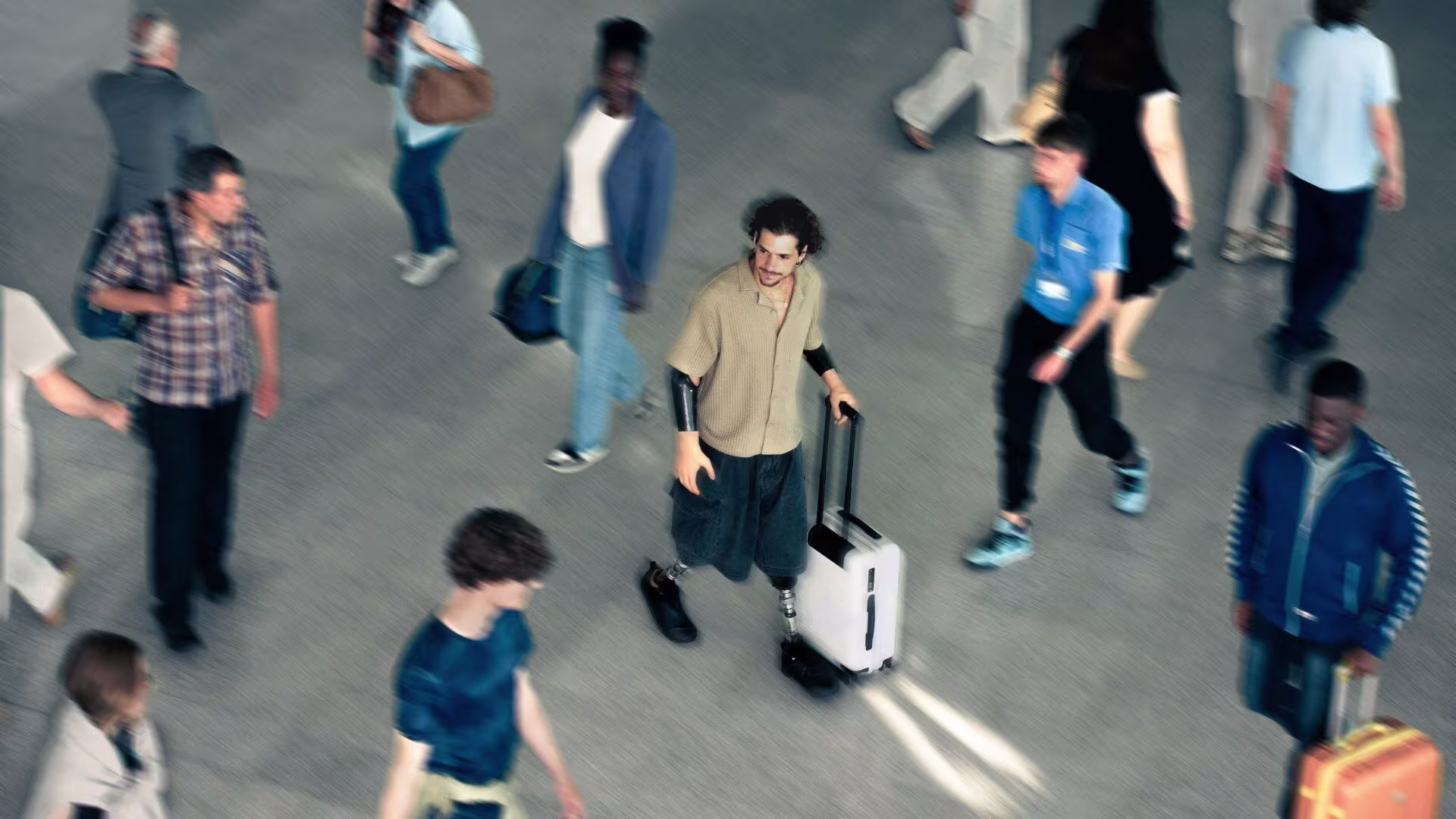 A bilateral lower limb amputee walking through a crowded airport terminal