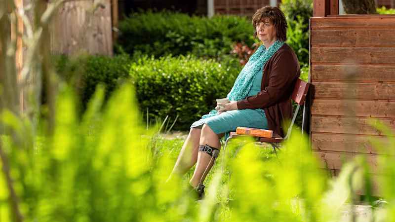 Silvia seduta in giardino con la sua ortesi Ottobock Agilium Freestep
