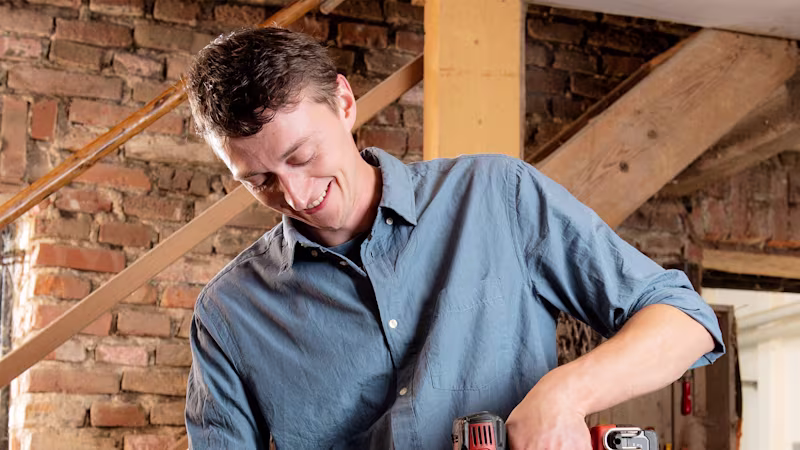 A man with a Greifer prosthetic hand from Ottobock using a drill.