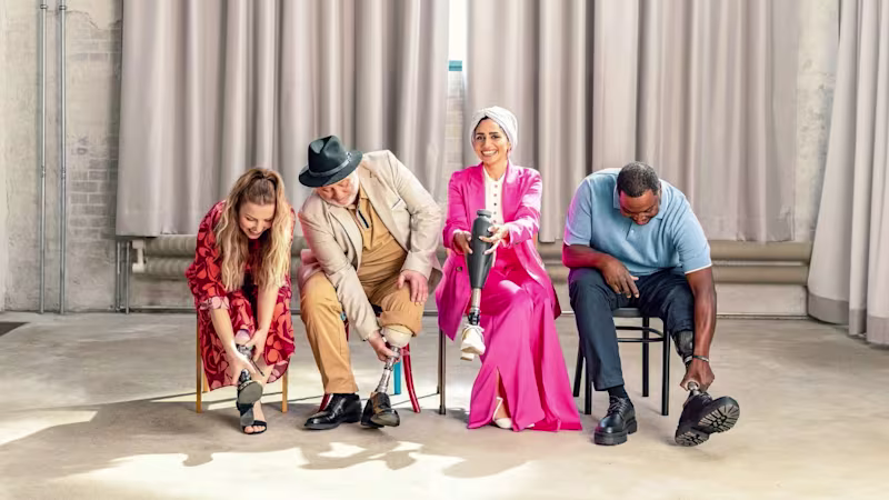 Four individuals seated indoors, each adjusting or fitting a prosthetic leg, highlighting Ottobock’s advanced mobility solutions and personalized care.