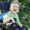 Un enfant en fauteuil roulant sourit