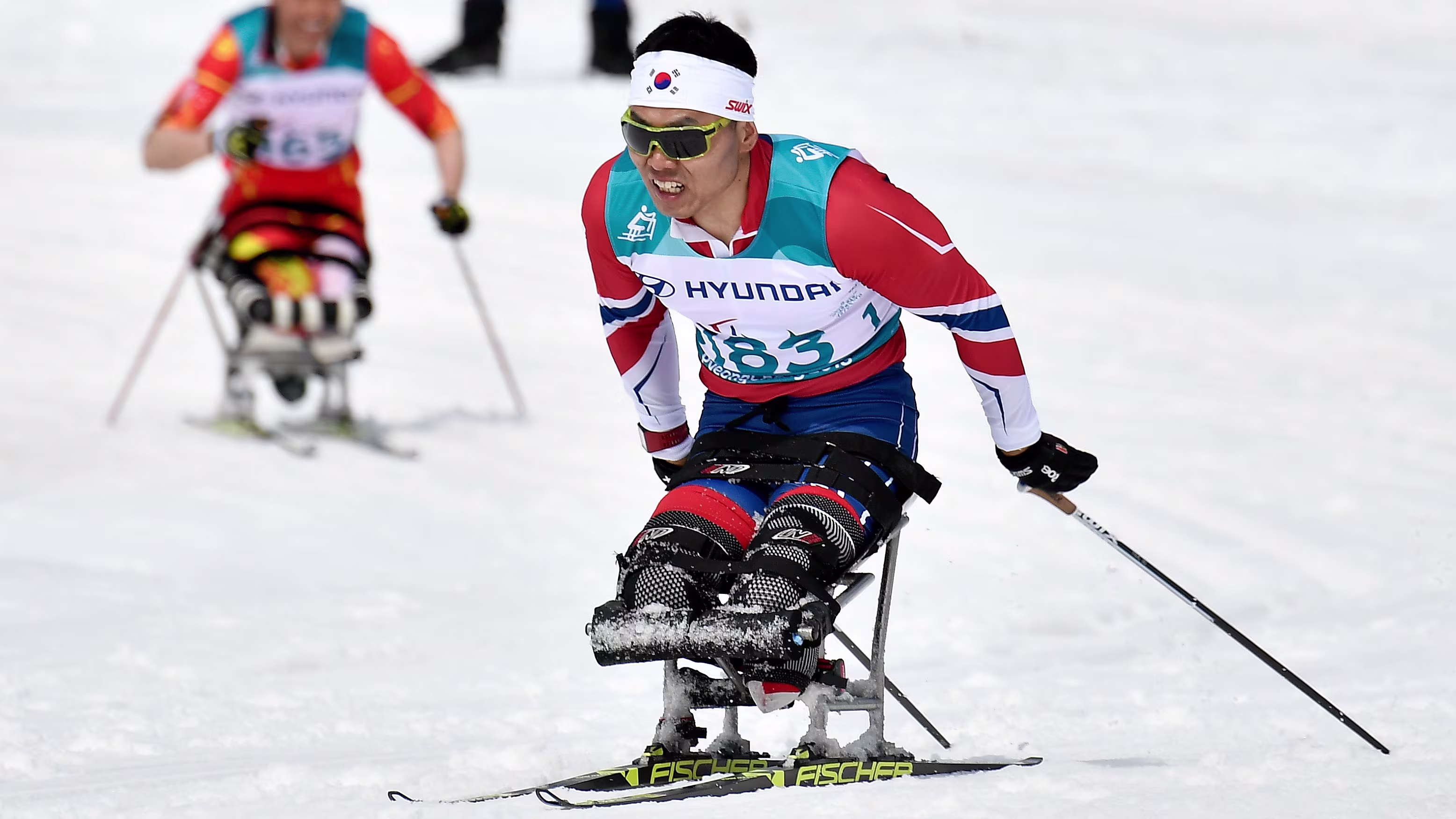 Two athletes with limb difference competing in nordio skiing