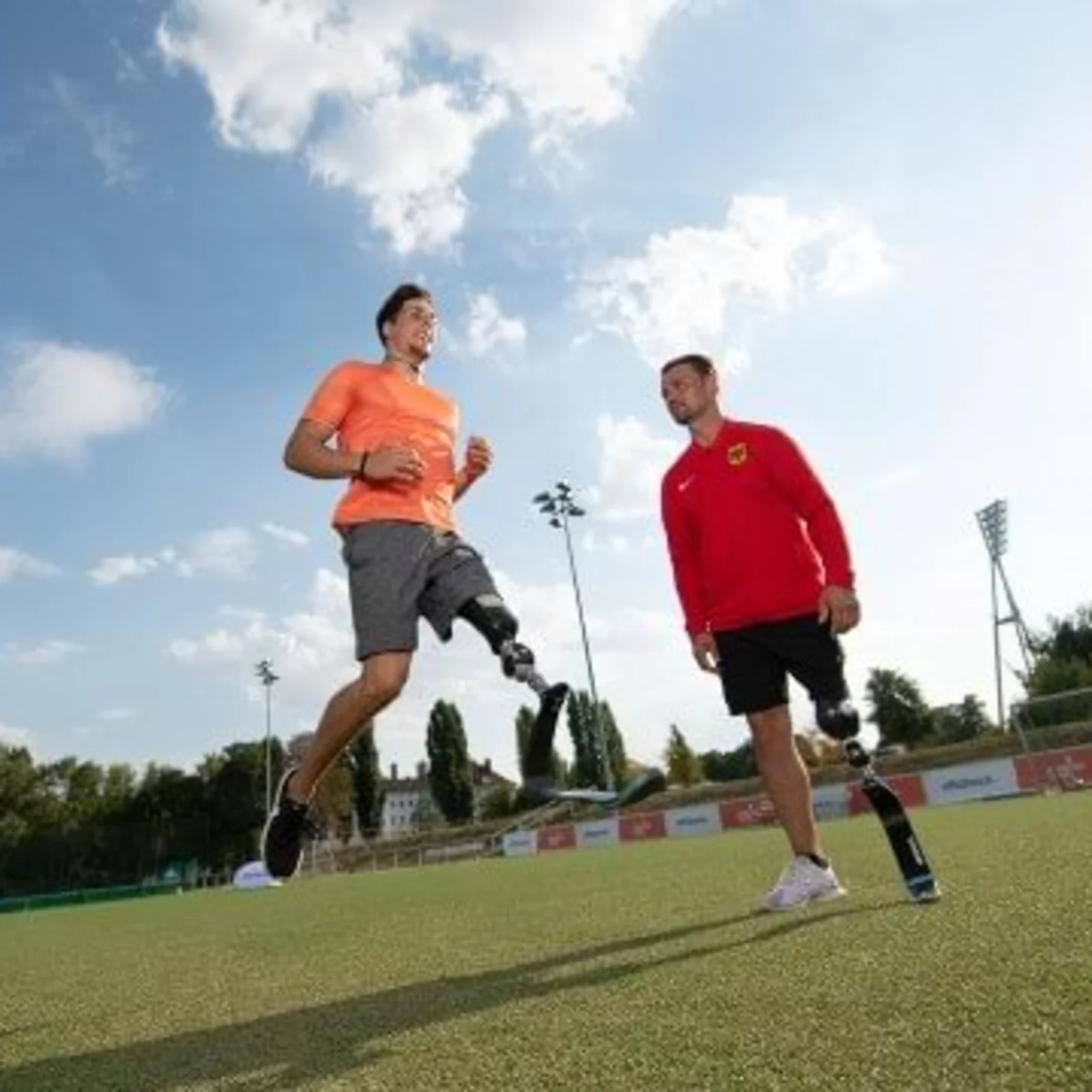 Two Paralympic athletes prepare for a football game in an outdoor sports field