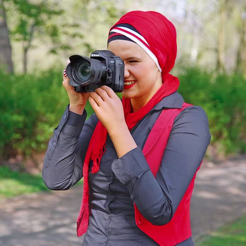 A photographer stabilizing their camera with their prosthetic arm
