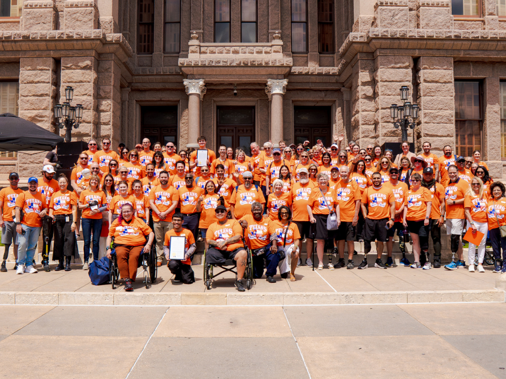 Un groupe de défenseurs vêtus d’orange pour représenter la perte des membres et la différence des membres Mois de sensibilisation
