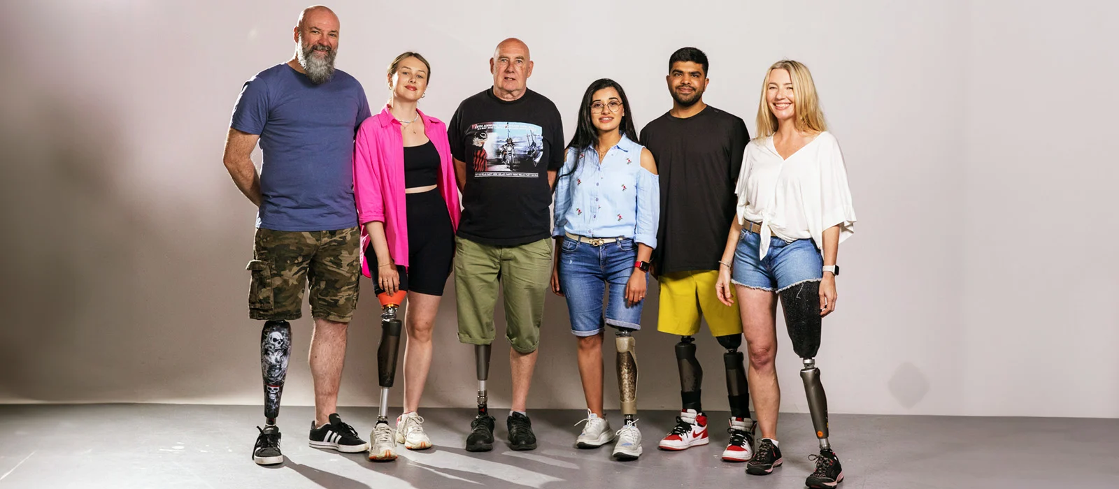 Six C-Leg Prosthetic Leg Users Standing against a white background. 