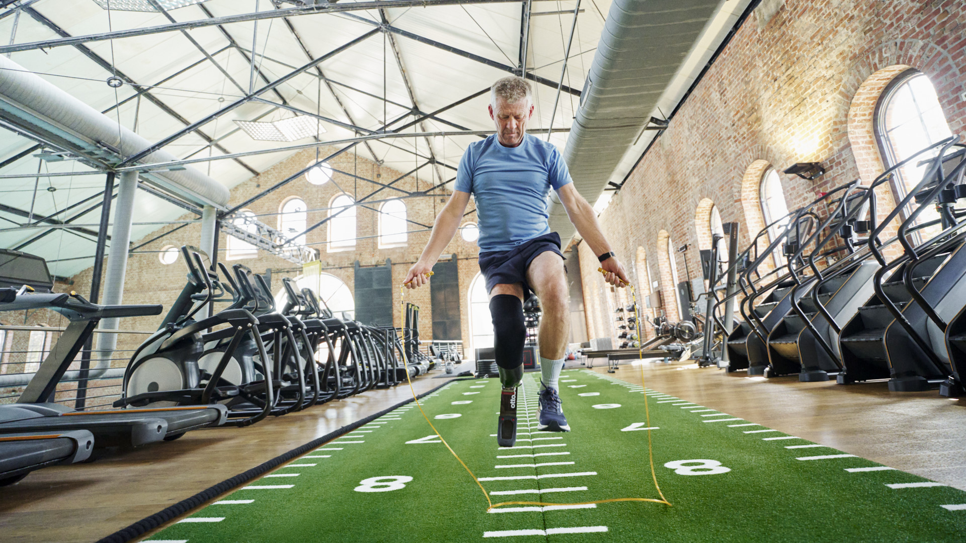 An adaptive athlete jumping rope in an indoor gym