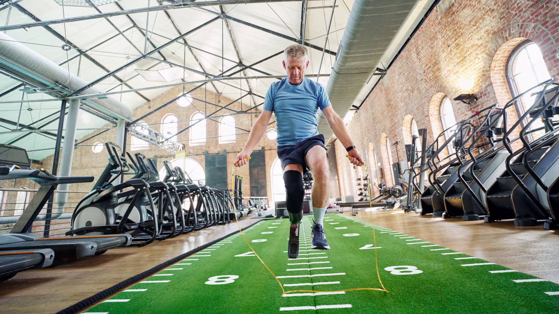 An adaptive athlete jumping rope in an indoor gym