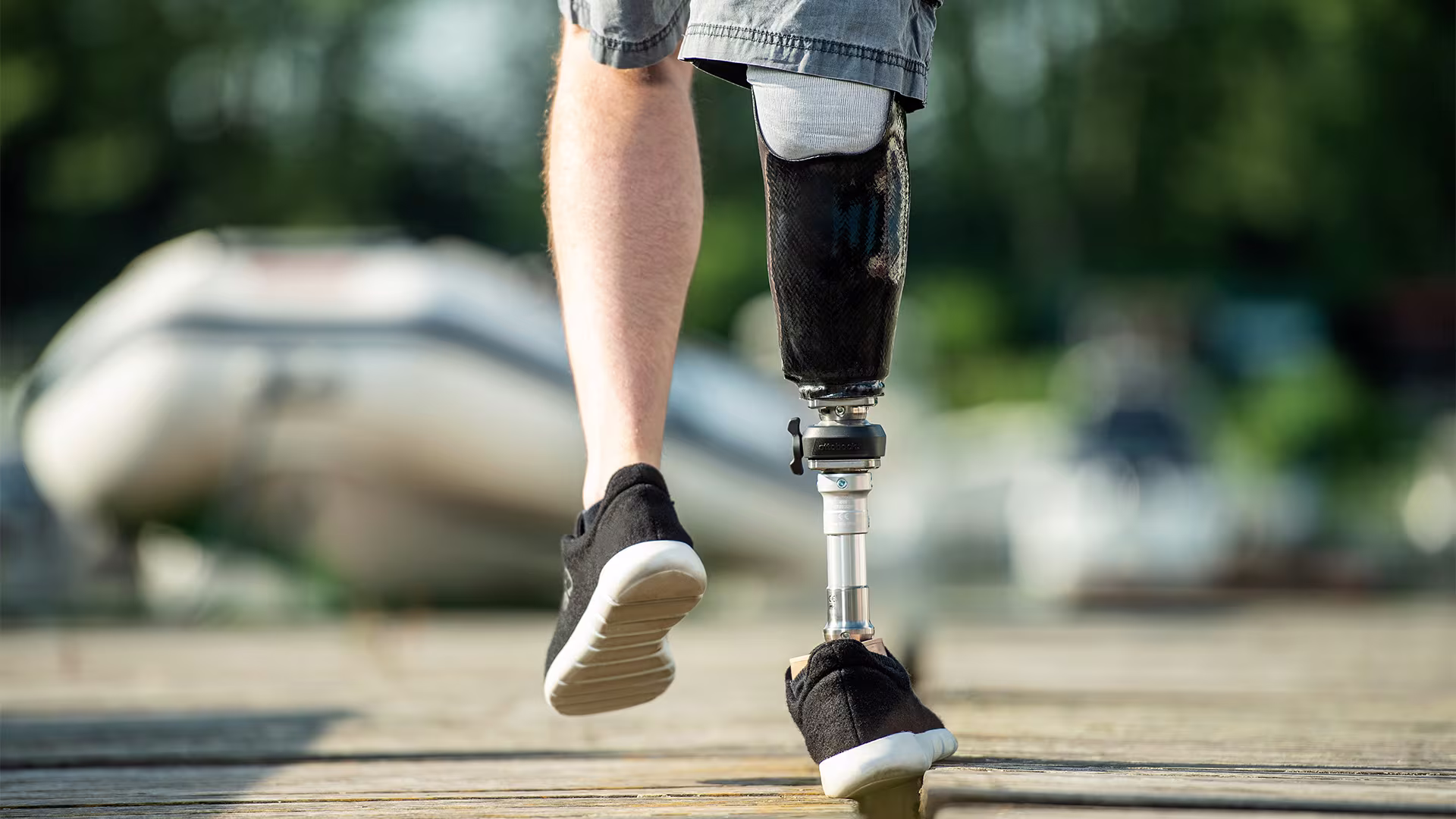 A man with a Taleo Side Flex prosthetic foot is balancing on a thin wooden beam